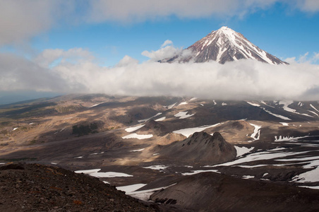 从阿瓦钦斯基的斜坡上看到的科拉克斯基火山。 科拉克斯卡娅索普卡从云层上方升起。 叫做骆驼的挤压岩石可以在下面看到。 纳莱切沃自