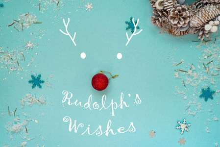 鲁道夫鹿的剪影与鼻子由一个红色圣诞树球和被绘的垫铁与文本 rudolphs 祝愿在蓝色背景