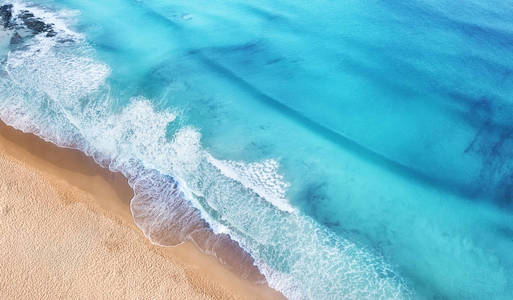 从顶部看海滩和海浪。 从顶部看绿松石水背景。 夏天从空中海景。 从无人机俯视。 旅游概念和理念