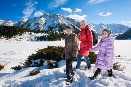 一家人母亲带着两个孩子在冬山上散步