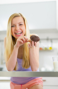 快乐的年轻女人吃巧克力松饼