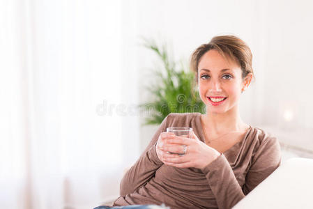 快乐的年轻妇女喝矿泉水图片