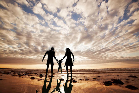 幸福的一家人手牵手在沙滩上图片