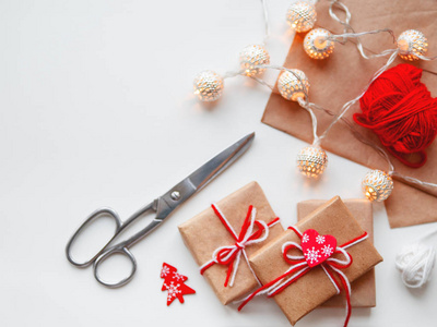 DIY礼物包裹在工艺纸上。 礼物绑着白色和红色的线与红色的心符号。