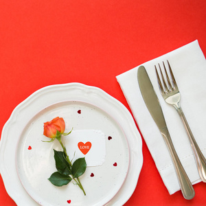 s day. plate, Cutlery, rose and card on red background. Copy spa