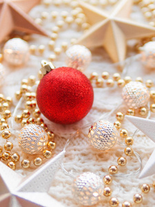 圣诞节和新年明星装饰白色针织背景。 金属灯泡，图案精致，金色珠子，红色球。