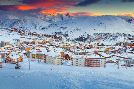 令人叹为观止的彩色冬季日落景观，著名的滑雪胜地，现代木制建筑，法国阿尔卑斯山，法国色调，法国，欧洲
