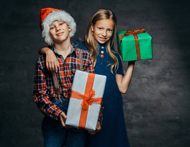 快乐的小夫妇拥抱和举行礼品盒在圣诞节时间