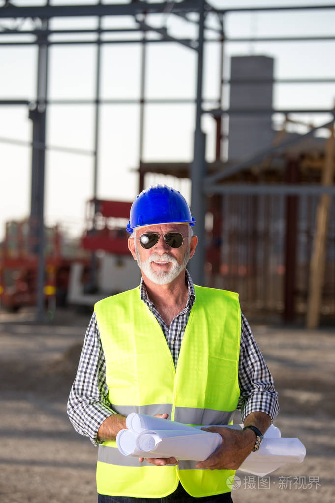建筑工地金属结构前戴安全帽,背心的高级工程师画像