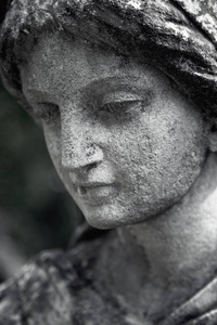 圣母像的脸。悲伤中的悲伤妇女的老式雕塑碎片宗教信仰苦难爱情概念
