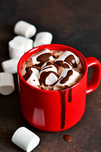 自制热巧克力与棉花糖和肉桂在一个红色的杯子。