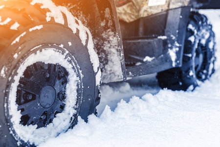 冬天在森林里关闭ATV4WD四轮自行车。 所有的地面车辆都站在大雪中，有很深的车轮轨道。 季节性极限运动冒险和旅行。 共空间。