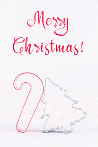 糖果和圣诞树饼干切割机在白色闪闪发光的背景与博克灯。 节日圣诞卡背景。 垂直的。 假日措辞