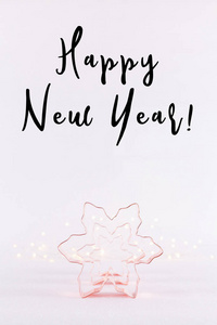 一排雪花铜饼干切割机在白色闪闪发光的背景与波克灯。 节日和新年卡片背景。 垂直的。 假日措辞