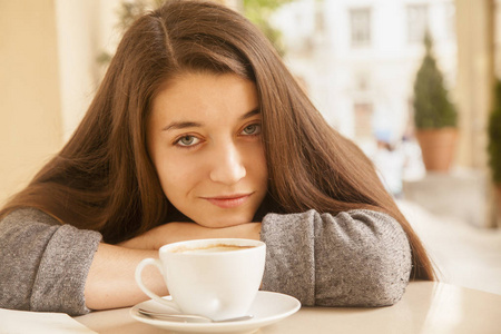 咖啡。 美丽的女孩在咖啡馆里喝咖啡。 美女模特拿着一杯饮料。