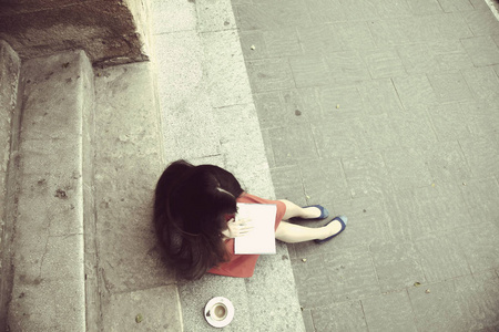 美丽的年轻女人看书喝咖啡。 放松浪漫诗休息
