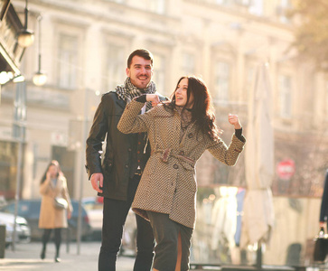 浪漫的幸福的年轻夫妇在旅游城市里，在夕阳下一起玩