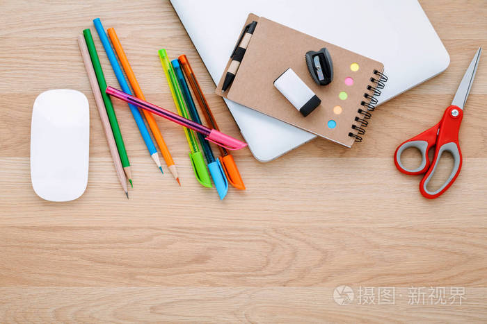 回到学校的概念与学校用品,笔记本电脑,书,笔,彩色铅笔在木桌上.