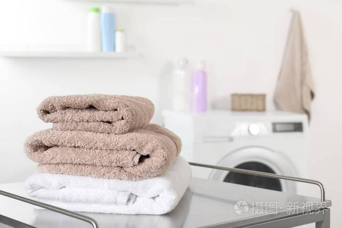 洗衣房桌子上的一叠干净的软毛巾。 文本空间