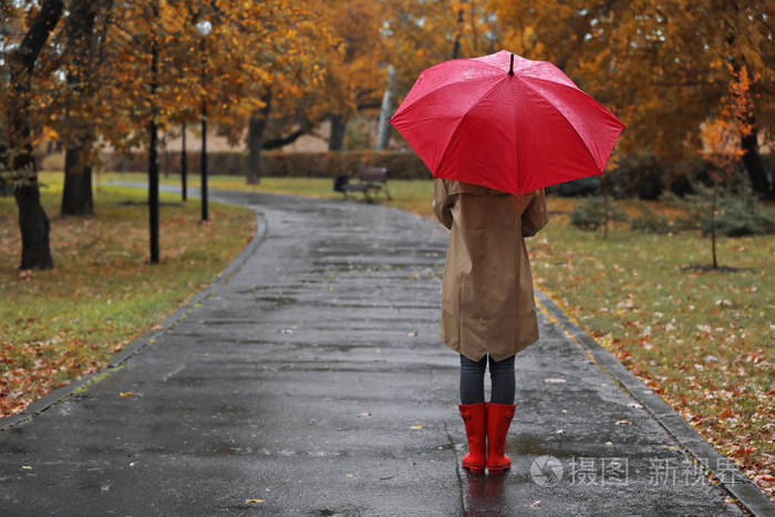 雨天秋天公园有伞的女人