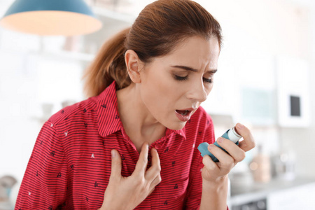 厨房用哮喘吸入器的年轻女性