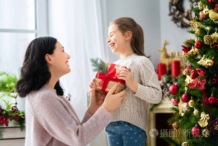 快乐的妈妈和她可爱的女儿交换礼物.
