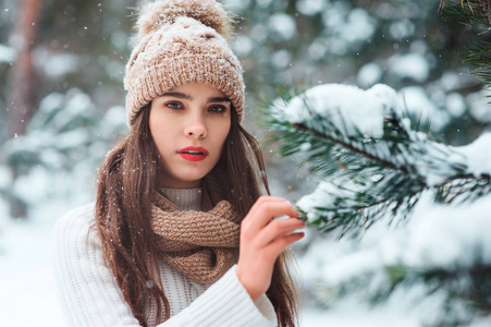 接近冬天的肖像，梦幻般的年轻女子走在雪地森林里，背景是树木