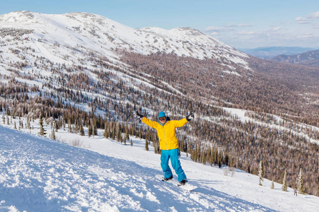 在山上度过寒假，快乐的年轻男性滑雪者骑在滑雪板上