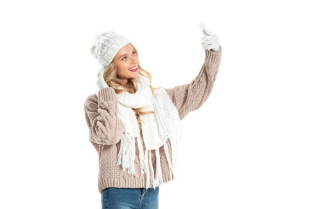 穿着冬装的美女自拍智能手机，与白色隔离