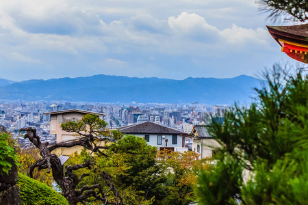 从Kiyomizu寺庙俯瞰京都城市，背景是戏剧性的多云天空。