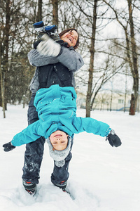 妈妈和小儿子在冬天的雪地里玩耍