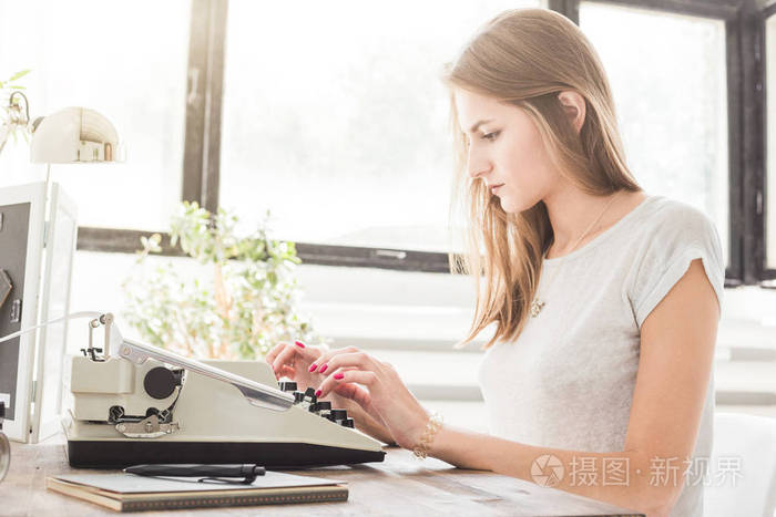 年轻的女商人在家工作, 在打字机上打字。创意斯堪的纳维亚风格的工作空间