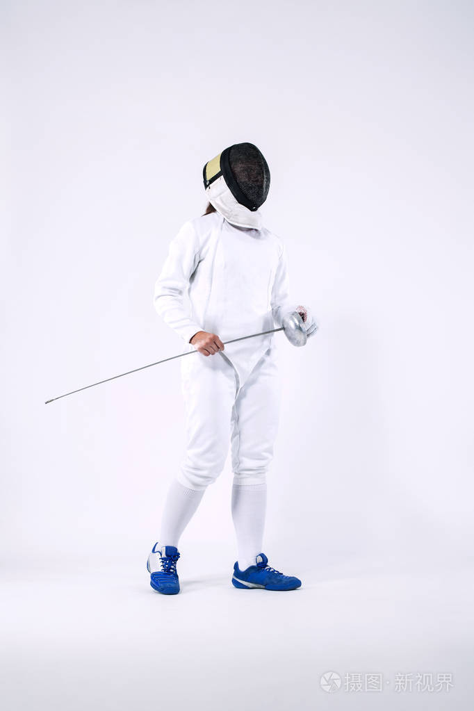 击剑运动员戴着面具穿着白色击剑服装拿着剑隔离在白色背景上