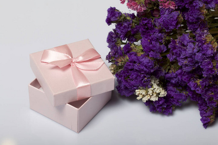 包装礼物。 礼品盒。 接下来是一束秋天干的花。 在白色的背景上。
