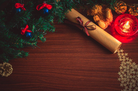 圣诞树树枝上有蓝色的球，一封带丝带的信，一只熊玩具星星纸屑，一个圆锥体，放在木桌上，平躺着，俯视复制空间。 美丽舒适的冬天背景，