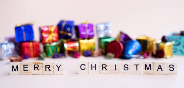 圣诞快乐字在木块与彩色圣诞礼品盒背景横幅