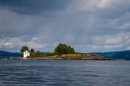 在挪威岩石般的海岸线上建造，少有松树，蓝天下平静的水