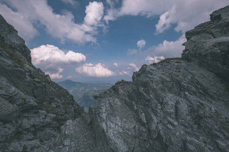 从斯洛伐克塔特拉山上的班尼科夫峰上的山景全景，岩石景观和徒步旅行者的影子在明亮的日子里，风暴云接近老式的旧电影的外观。