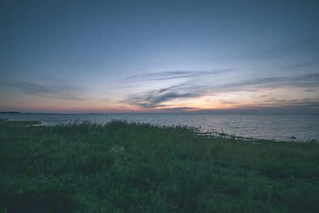 夕阳的红饱和色彩在波罗的海上空，平静的海水和爱沙尼亚的阳光反射