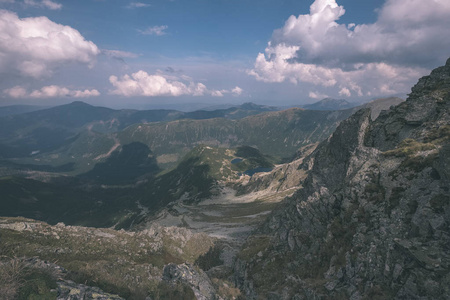 从斯洛伐克塔特拉山上的班尼科夫峰上的山景全景，岩石景观和徒步旅行者的影子在明亮的日子里，风暴云接近老式的旧电影的外观。