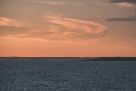 夕阳的红饱和色彩在波罗的海上空，平静的海水和爱沙尼亚的阳光反射