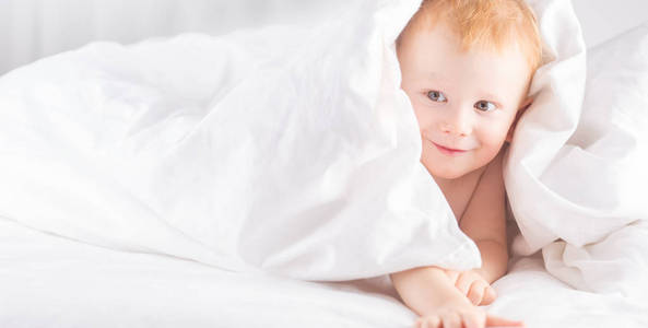 哈比年轻的孩子在白色的床上。