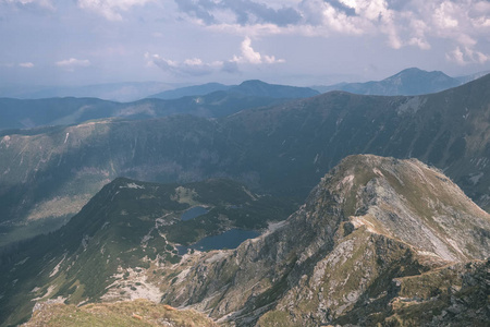 从斯洛伐克塔特拉山的巴尼科夫峰顶俯瞰美丽的山脉全景，岩石景观和徒步旅行者的阴影在明亮的白天与风暴云