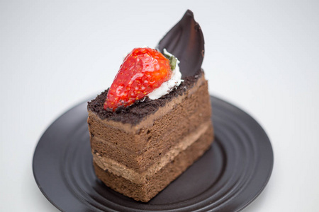 白桌上放着草莓巧克力蛋糕