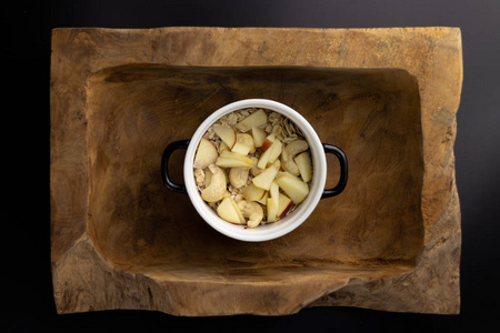 一份美味的早餐，上面放着燕麦苹果坚果和辣椒籽，放在一个漂亮的樵夫碗上。