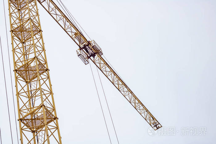 黄色建筑起重机在蓝天背景下的俯视图