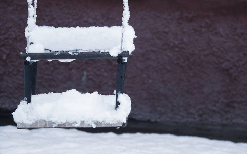 s swing covered snow in winter, close up.