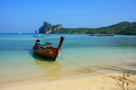 长尾船停泊在泰国帕菲岛克拉比岛的敖洛达勒姆海滩。 科菲皮顿是海洋国家公园的一部分。