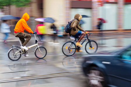 自行车骑手在雨天城市图片与运动模糊效果