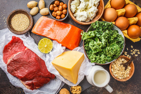 蛋白质食品鱼肉,鸡蛋,奶酪,藜麦坚果,在黑暗的背景顶部视图.照片